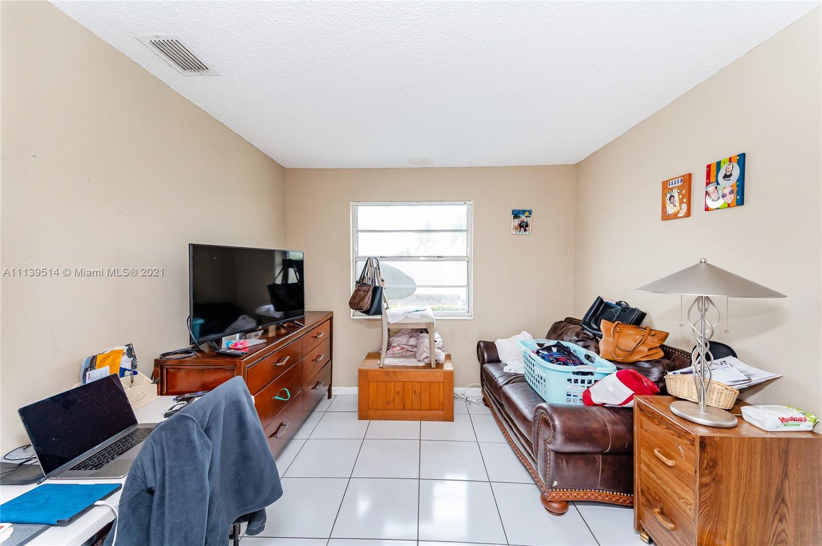 15280 Southwest 80th Street, Unit 11 Miami, FL 33193 - Photo 9 of 13 a room with furniture and a flat screen tv