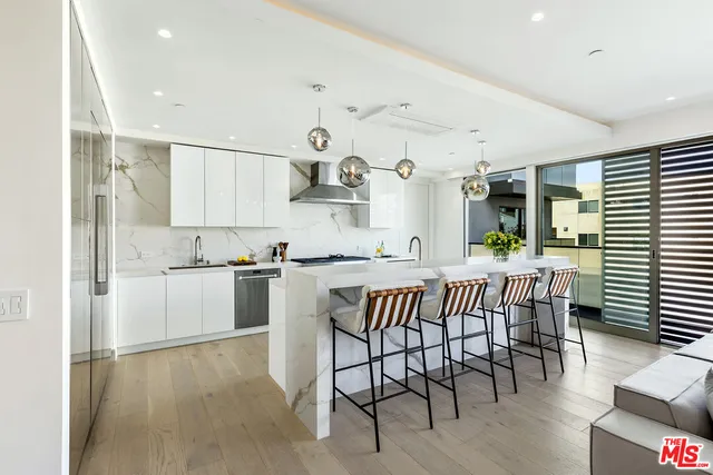 a kitchen with stainless steel appliances kitchen island granite countertop a sink and a large window