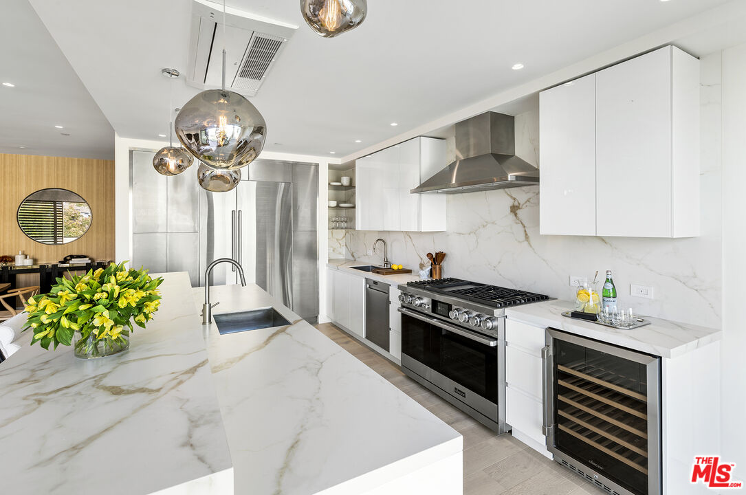 1644 Malcolm Avenue, Unit 420 Los Angeles, CA 90024 - Photo 21 of 64 a kitchen with stainless steel appliances a stove a sink cabinets and a window