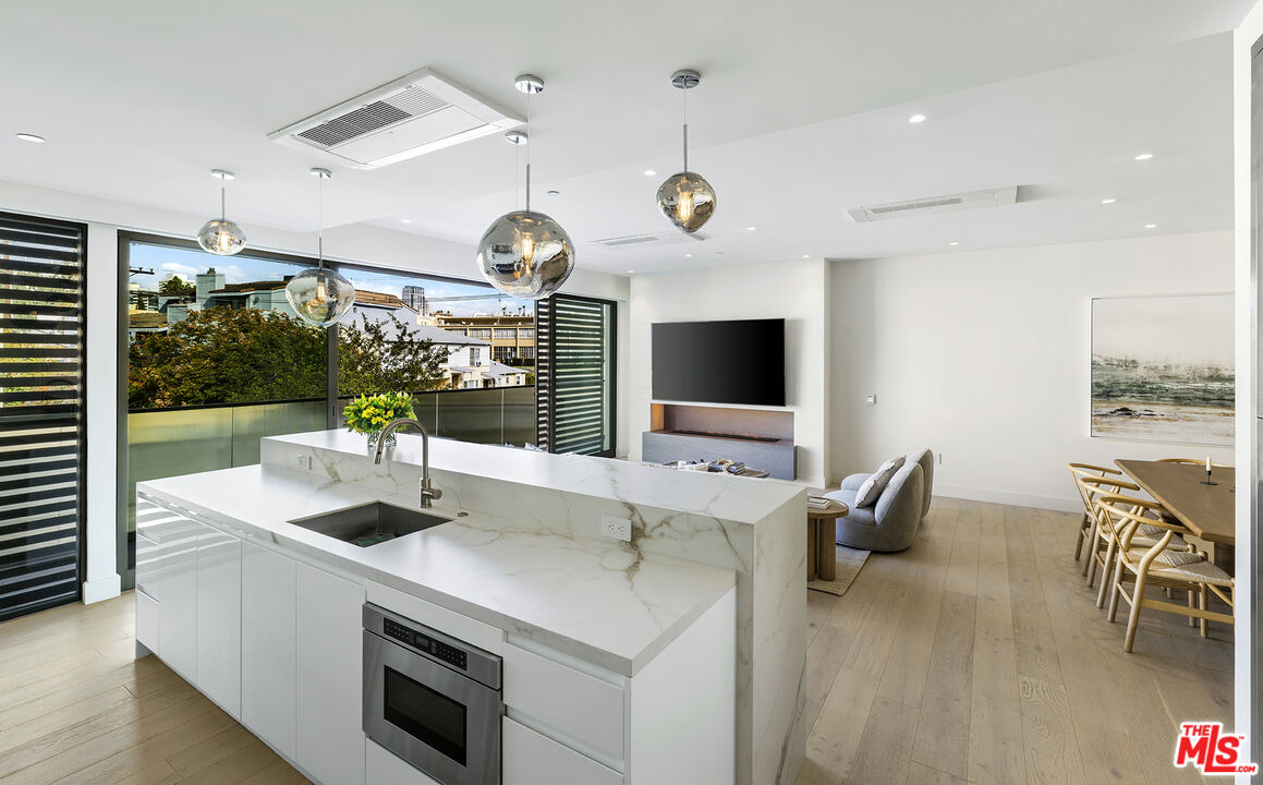 1644 Malcolm Avenue, Unit 420 Los Angeles, CA 90024 - Photo 23 of 64 a kitchen with stainless steel appliances kitchen island granite countertop a sink and a large window