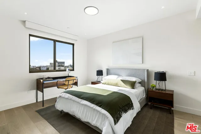 a bedroom with a bed and large window