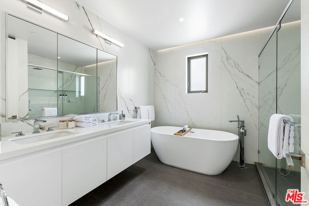 1644 Malcolm Avenue, Unit 420 Los Angeles, CA 90024 - Photo 39 of 64 a spacious bathroom with a double vanity sink mirror and bathtub