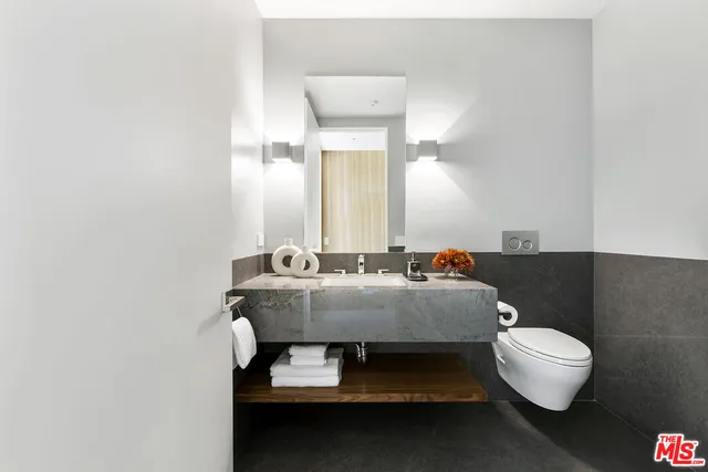 a roof deck with couches and potted plants with sky view