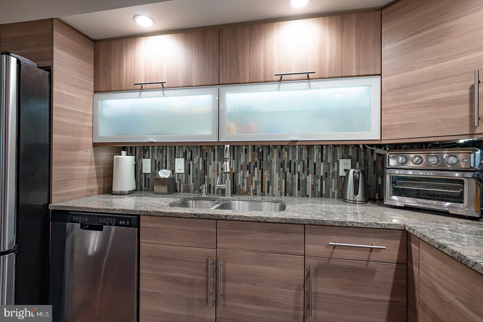 19 Rock Hill Road, Unit 1F Bala Cynwyd, PA 19004 - Photo 12 of 35 a kitchen with a refrigerator a sink and wooden cabinets