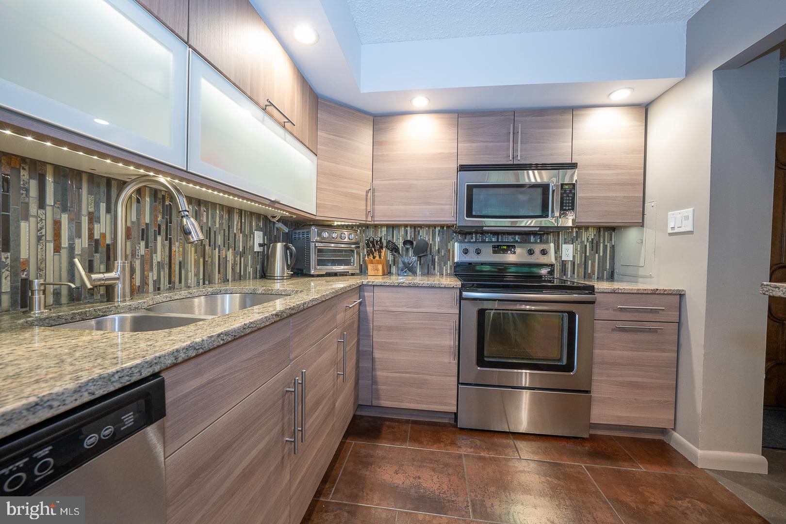 19 Rock Hill Road, Unit 1F Bala Cynwyd, PA 19004 - Photo 13 of 35 a kitchen with stainless steel appliances granite countertop a stove a sink and a microwave