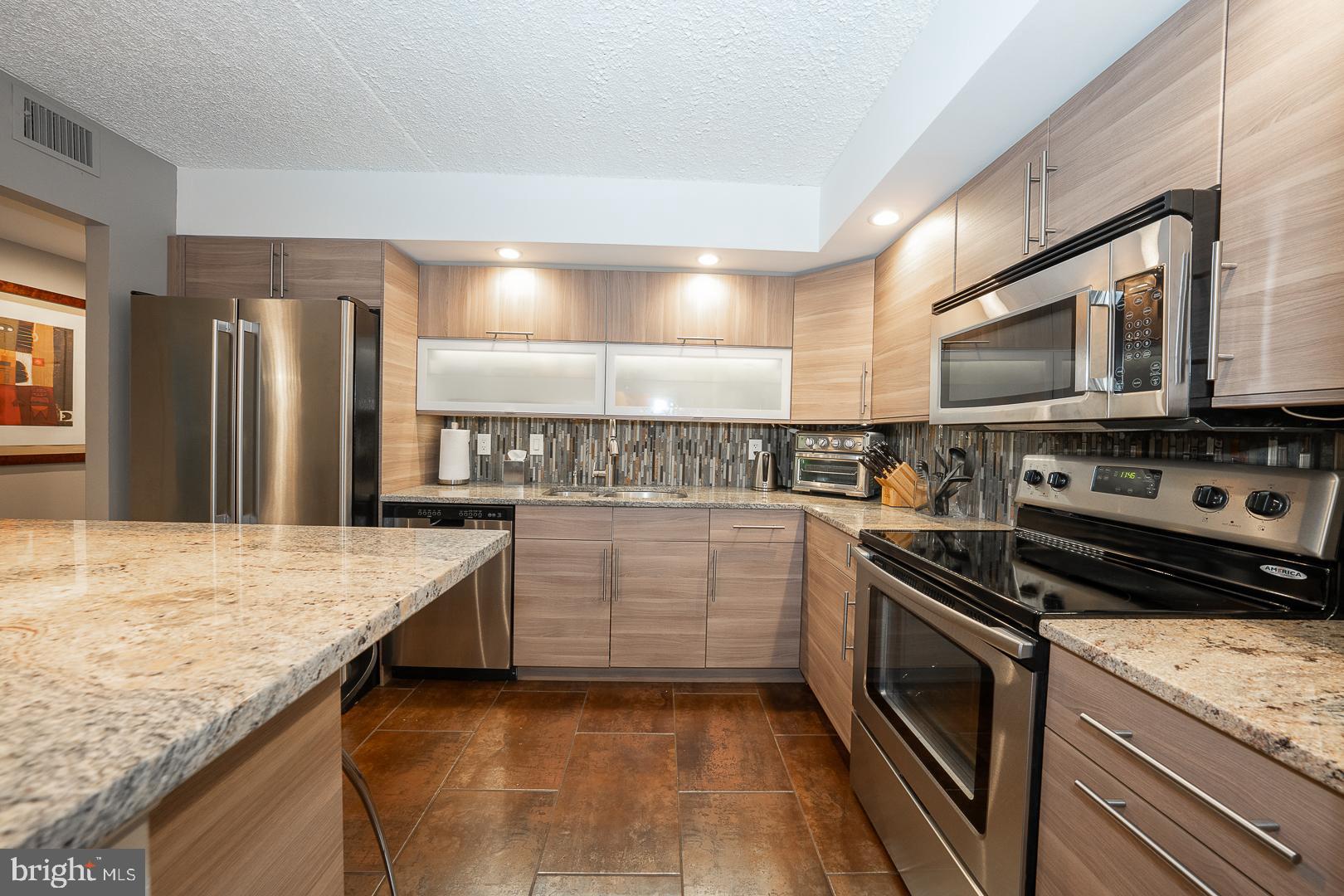 19 Rock Hill Road, Unit 1F Bala Cynwyd, PA 19004 - Photo 14 of 35 a kitchen with stainless steel appliances granite countertop a stove a sink and a microwave