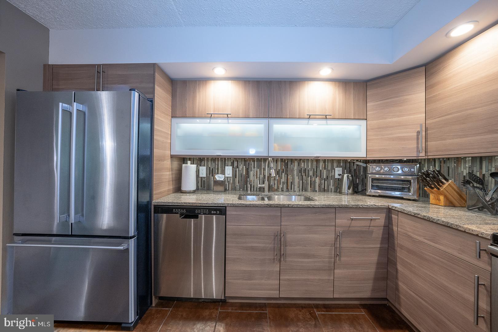19 Rock Hill Road, Unit 1F Bala Cynwyd, PA 19004 - Photo 15 of 35 a kitchen with stainless steel appliances granite countertop a refrigerator a sink and a stove