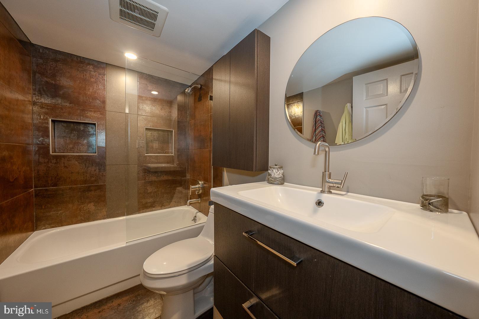 19 Rock Hill Road, Unit 1F Bala Cynwyd, PA 19004 - Photo 22 of 35 a bathroom with a bathtub shower sink mirror vanity and toilet