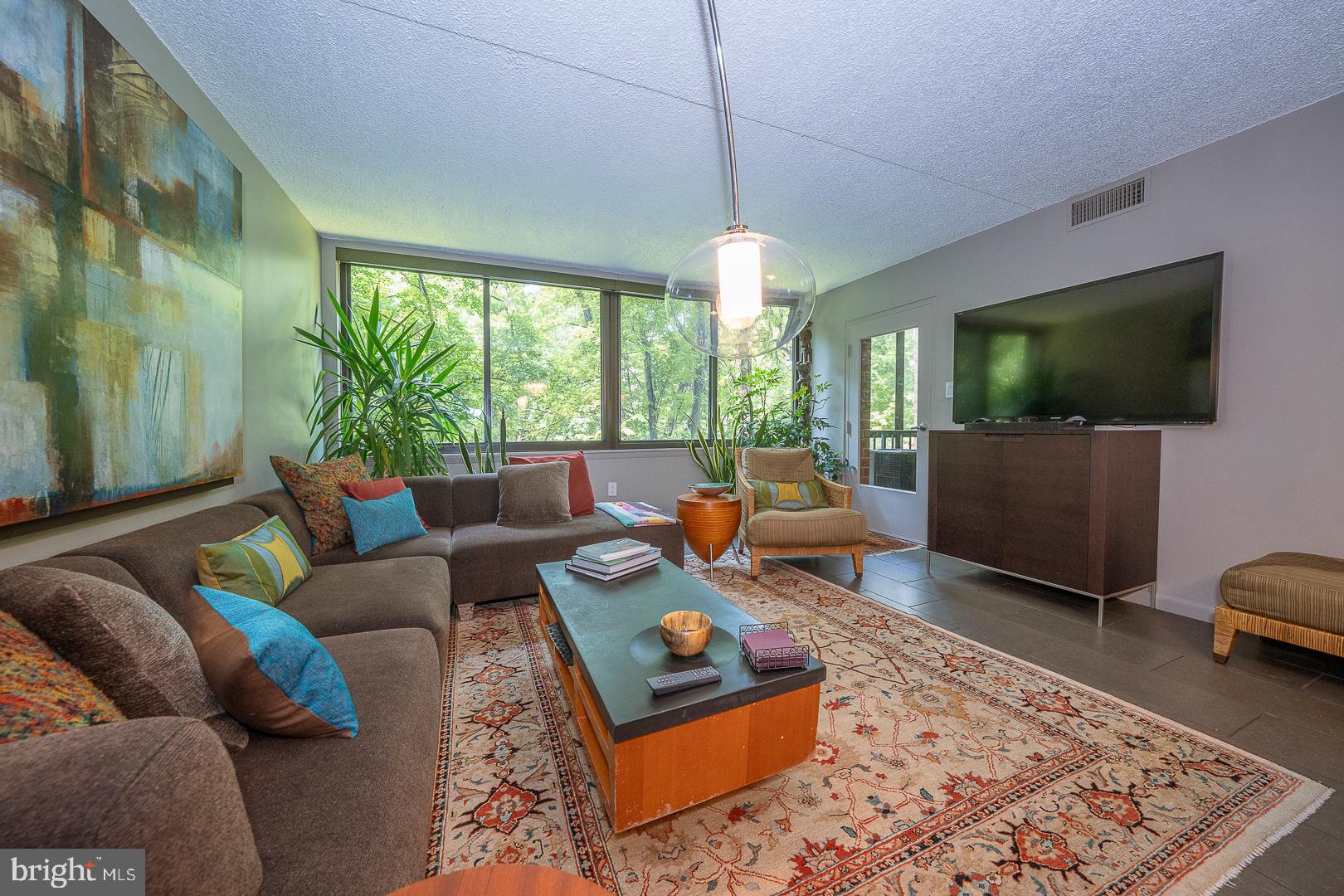 19 Rock Hill Road, Unit 1F Bala Cynwyd, PA 19004 - Photo 6 of 35 a living room with furniture and a flat screen tv