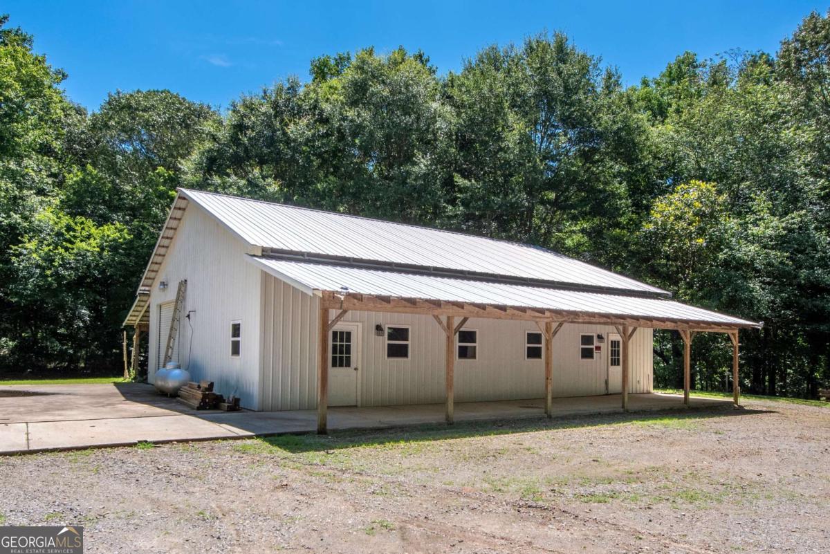 755 Harris Road Jasper, GA 30143 - Photo 14 of 62 a view of a white house with a large tree and plants