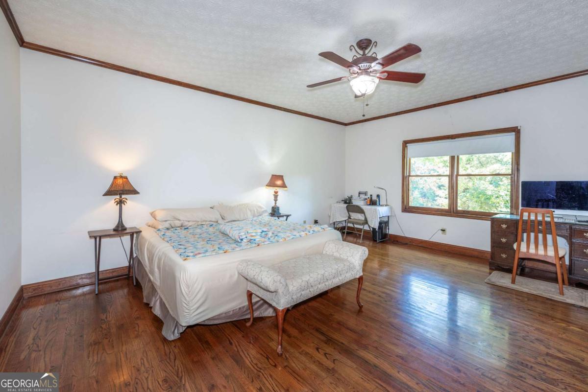 755 Harris Road Jasper, GA 30143 - Photo 40 of 62 a bedroom with a bed and a table in it with wooden floor