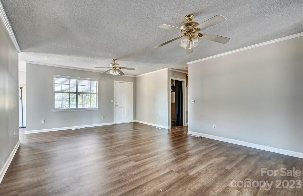 363 Griggs Road Clover, SC 29710 - Photo 8 of 26 an empty room with wooden floor chandelier and windows