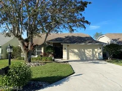 a front view of a house with a garden and yard