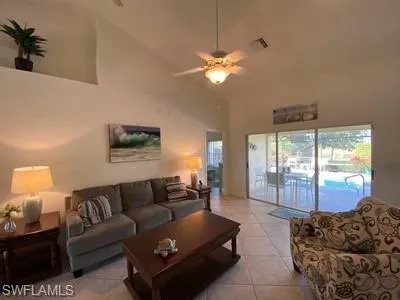 a living room with furniture a large window and a chandelier