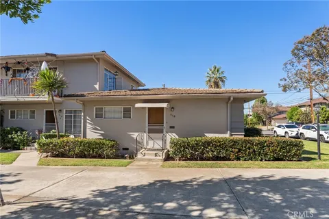 a front view of a house with a yard and potted plants