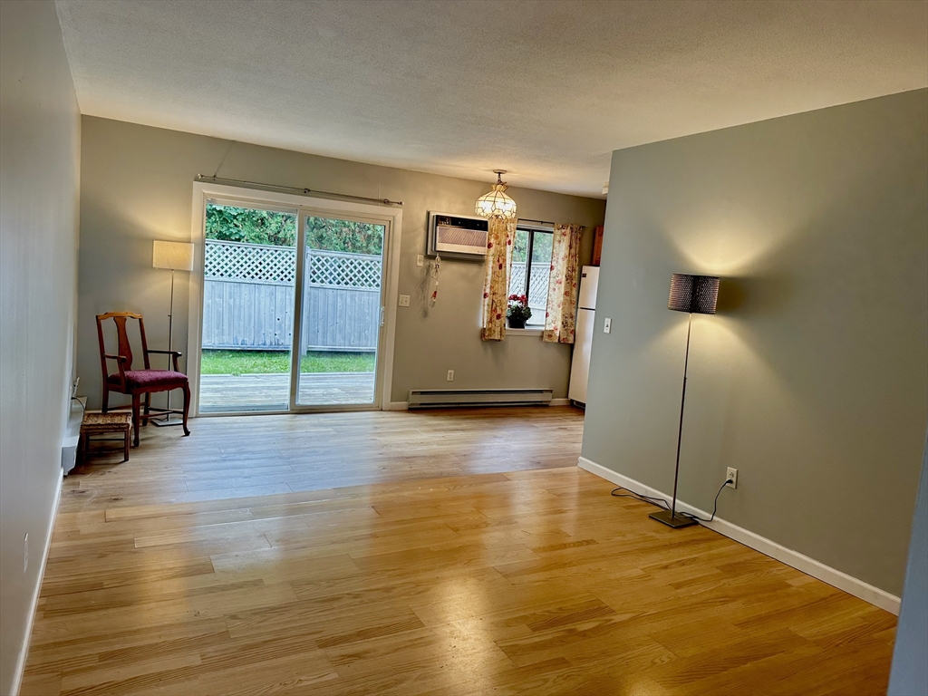 170 East Hadley Road, Unit 11 Amherst, MA 01002 - Photo 4 of 16 a view of empty room with wooden floor and fan