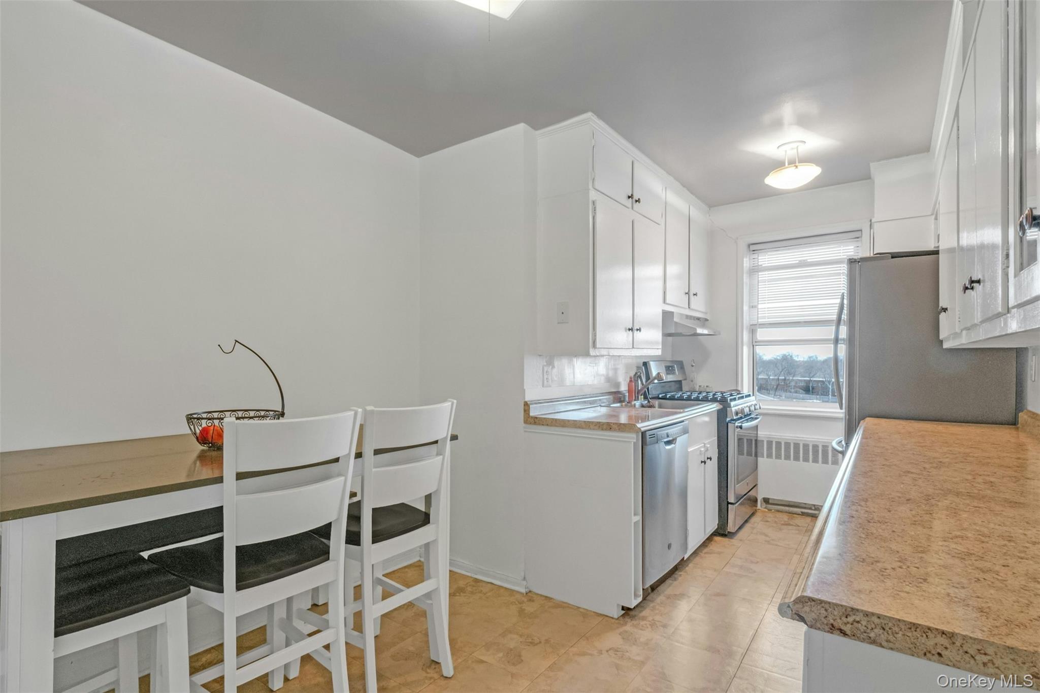 1234 Midland Avenue, Unit 5F Bronxville, NY 10708 - Photo 8 of 13 a kitchen with stainless steel appliances granite countertop a stove a sink and a refrigerator