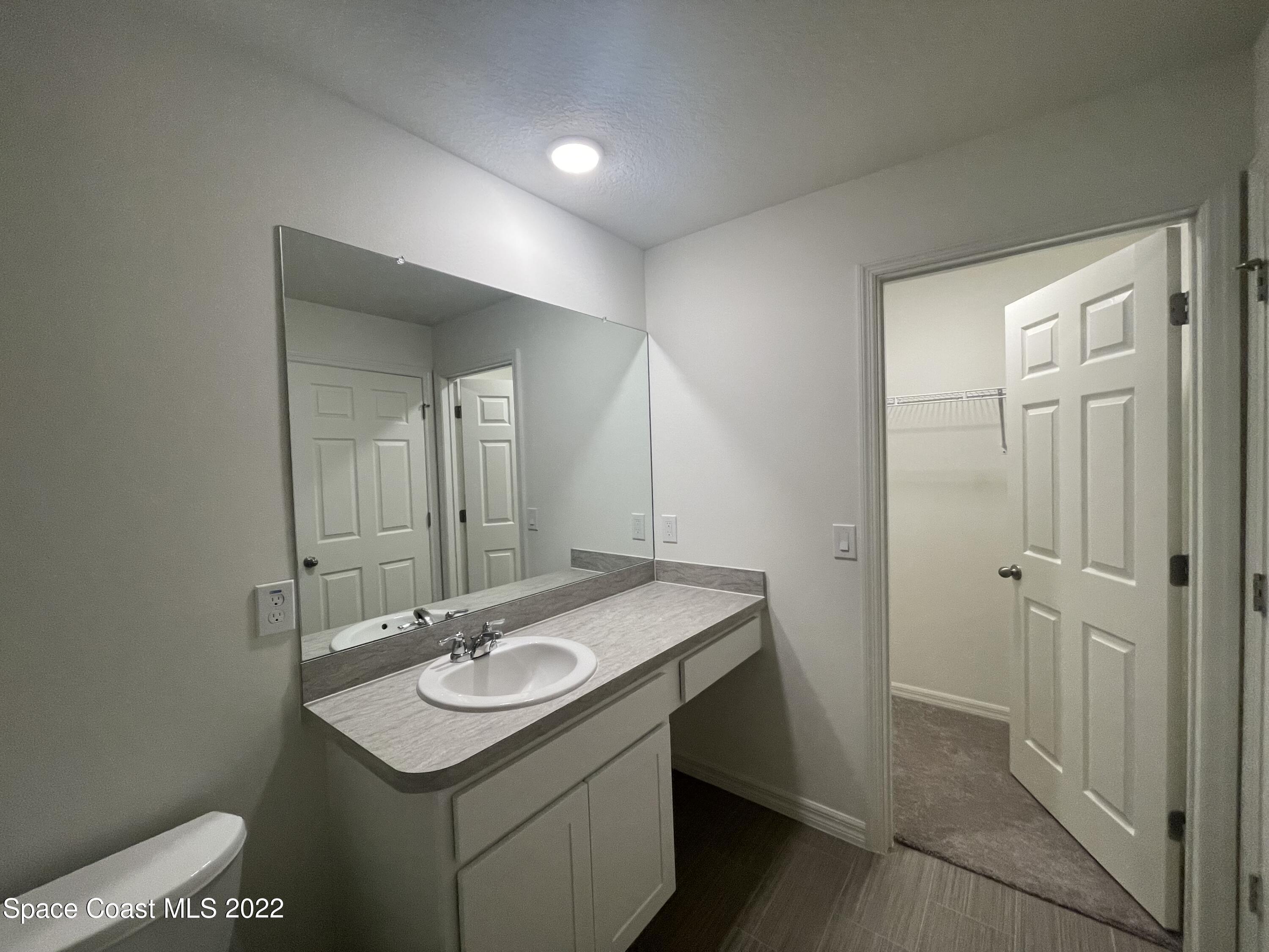 1215 Hastings Road Southwest Palm Bay, FL 32908 - Photo 11 of 16 a bathroom with a sink and a mirror