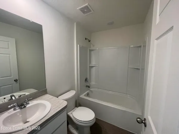 a bathroom with a sink toilet tub vanity and shower