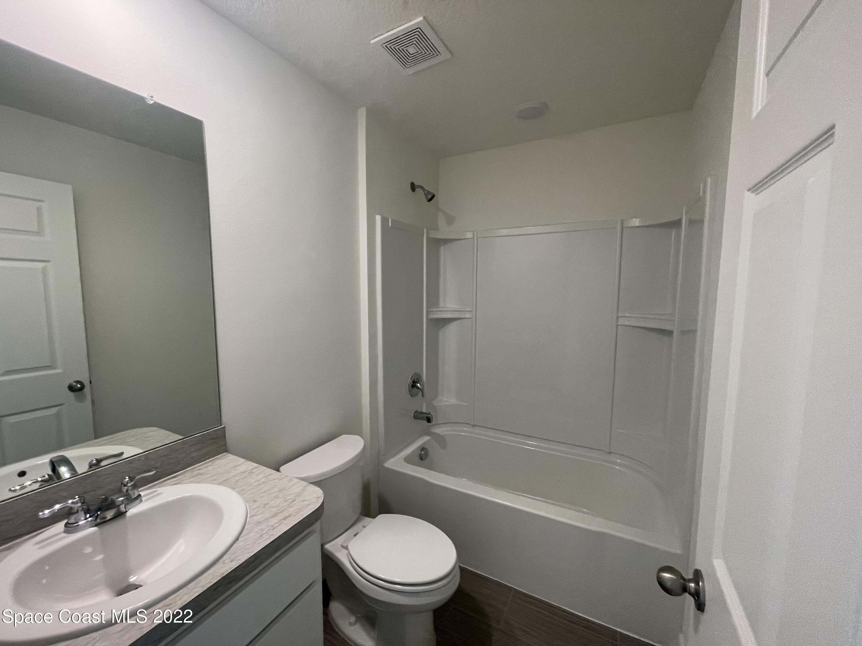 1215 Hastings Road Southwest Palm Bay, FL 32908 - Photo 14 of 16 a bathroom with a sink toilet tub vanity and shower