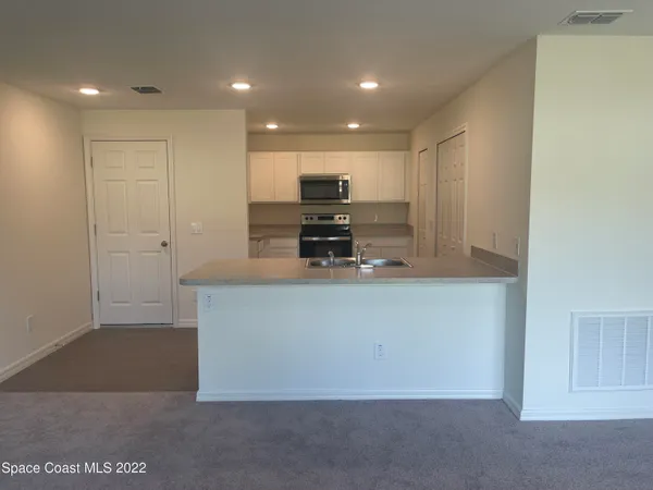a view of kitchen with stainless steel appliances cabinets