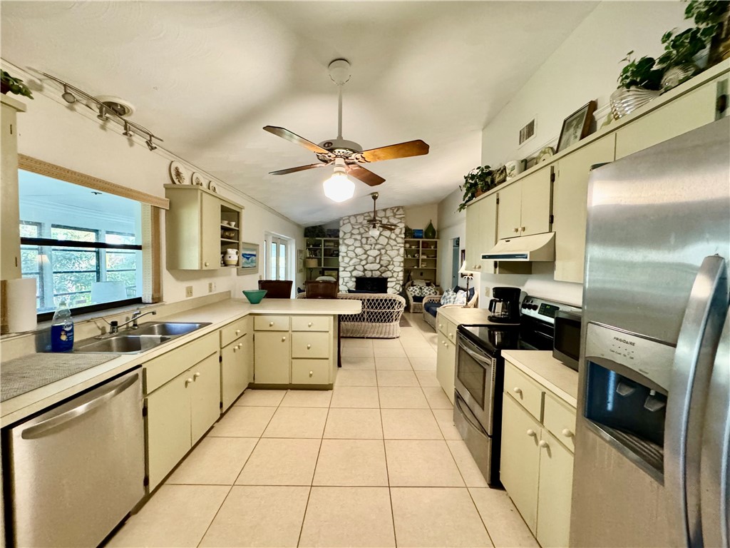 1946 Surfside Terrace Vero Beach, FL 32963 - Photo 12 of 36 a kitchen with stainless steel appliances lots of counter top space and windows