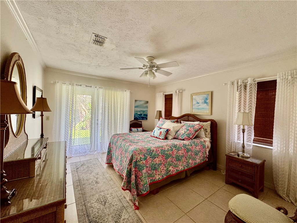 1946 Surfside Terrace Vero Beach, FL 32963 - Photo 26 of 36 a bedroom with a bed a couch and a flat tv screen on dresser