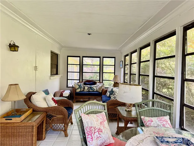a living room with furniture and floor to ceiling windows