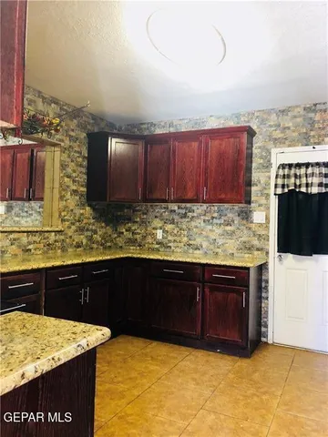 a large room with chandelier fan and windows