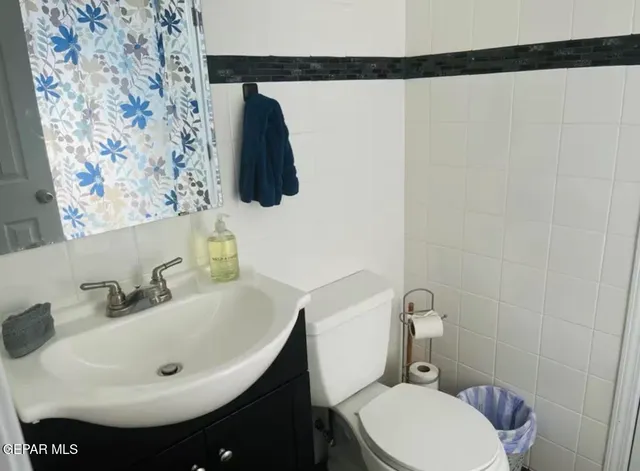 a bathroom with a sink a toilet a mirror and shower