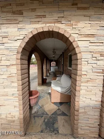 a patio with table and chairs and potted plants