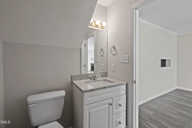 a bathroom with a granite countertop toilet a sink and a mirror