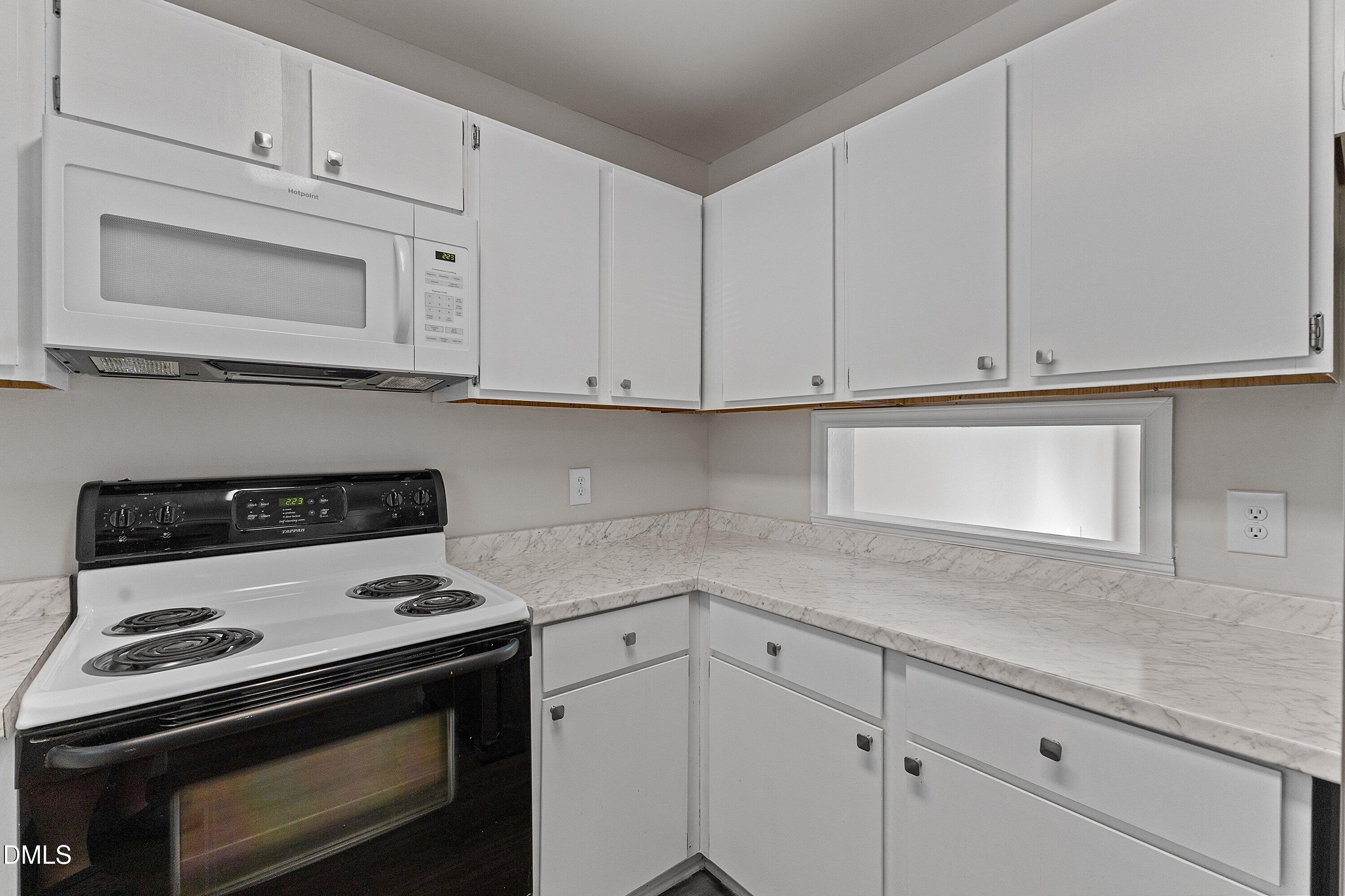 1900 Township Circle Raleigh, NC 27609 - Photo 6 of 19 a kitchen with white cabinets and appliances