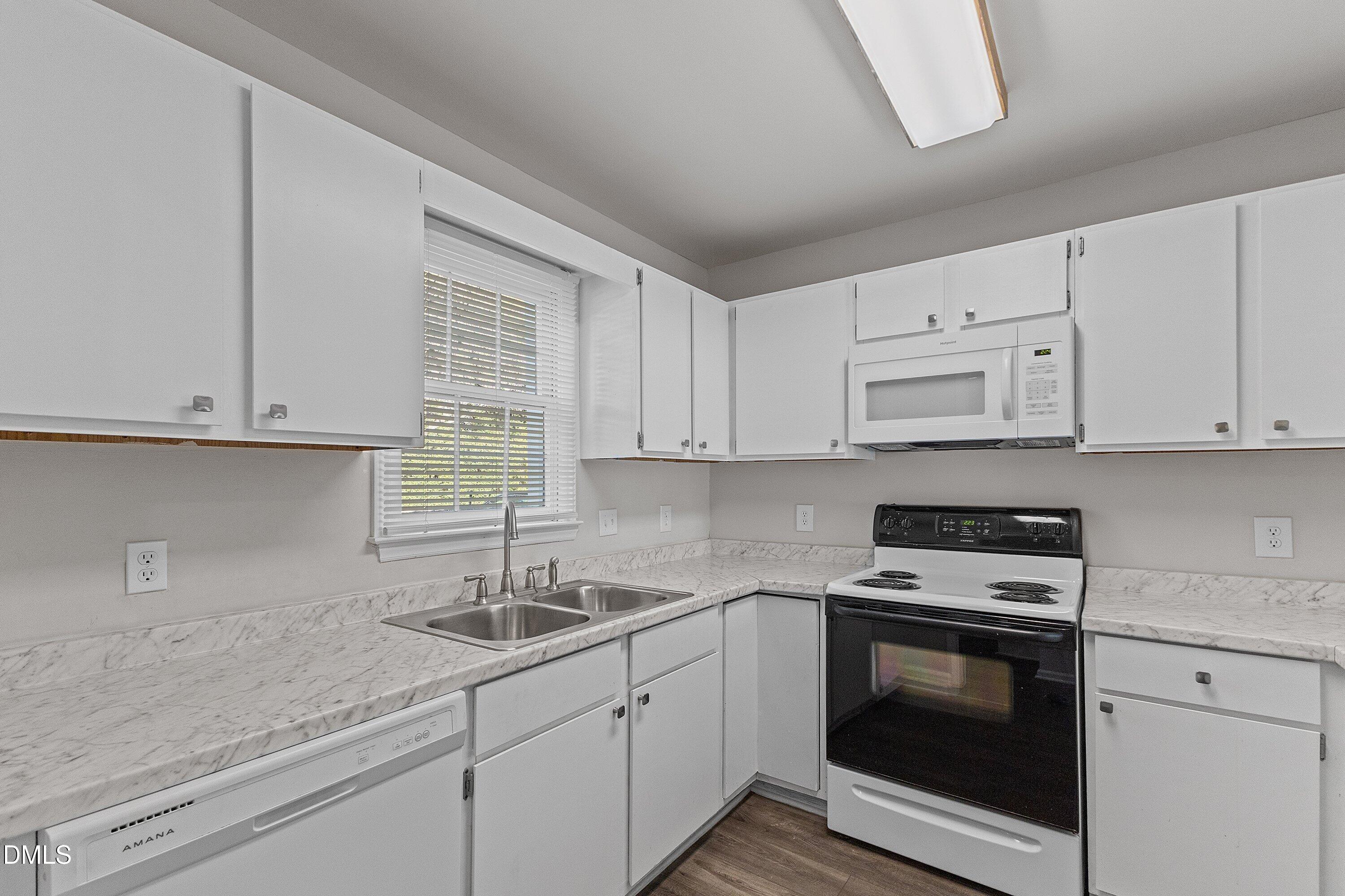 1900 Township Circle Raleigh, NC 27609 - Photo 7 of 19 a kitchen with granite countertop white cabinets and white appliances
