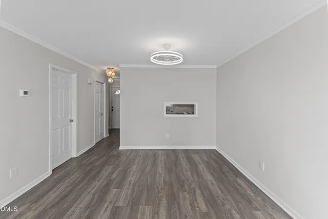 a view of a room with wooden floor and white walls