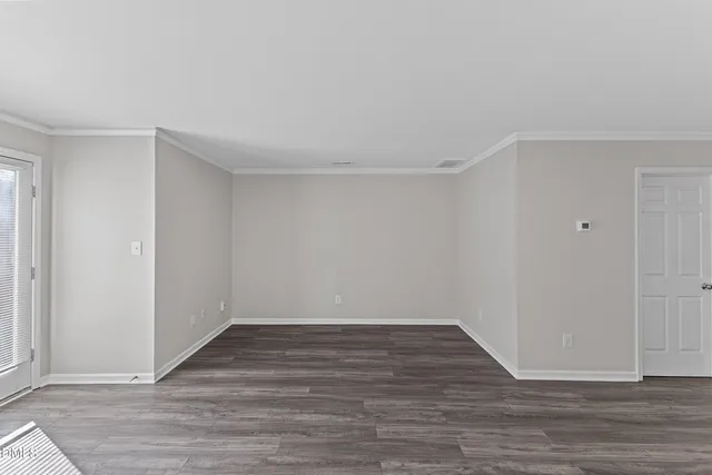 a view of an empty room with wooden floor