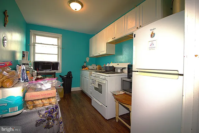 a kitchen with stainless steel appliances a stove a refrigerator sink and a dining table with chairs