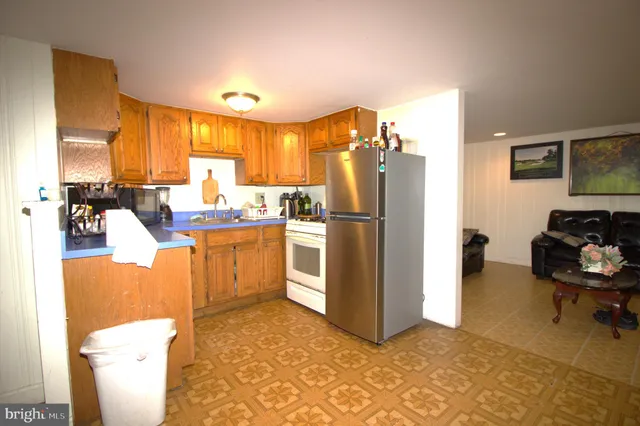 a kitchen with stainless steel appliances a refrigerator a sink a stove and white cabinets
