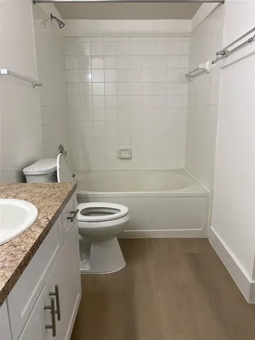 a bathroom with a granite countertop toilet a sink and bathtub