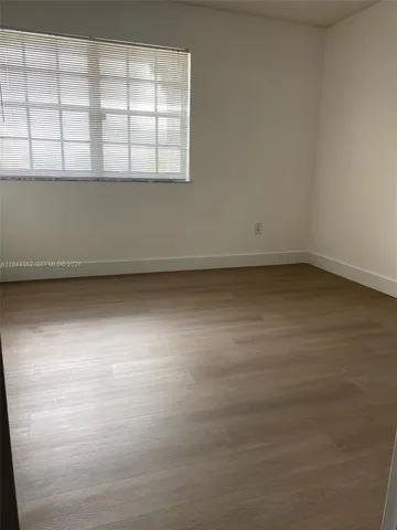 a view of a room with a wooden floor and window