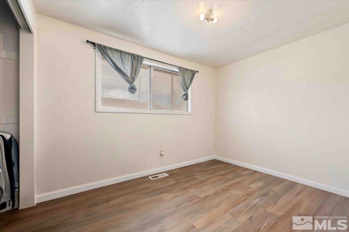 8925 Limnol Street Reno, NV 89506 - Photo 11 of 32 an empty room with wooden floor and windows