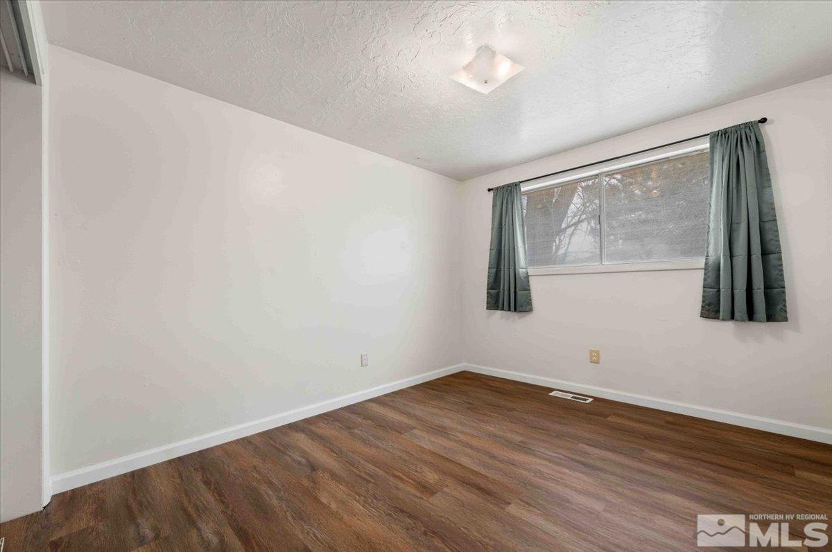 8925 Limnol Street Reno, NV 89506 - Photo 13 of 32 an empty room with wooden floor and windows