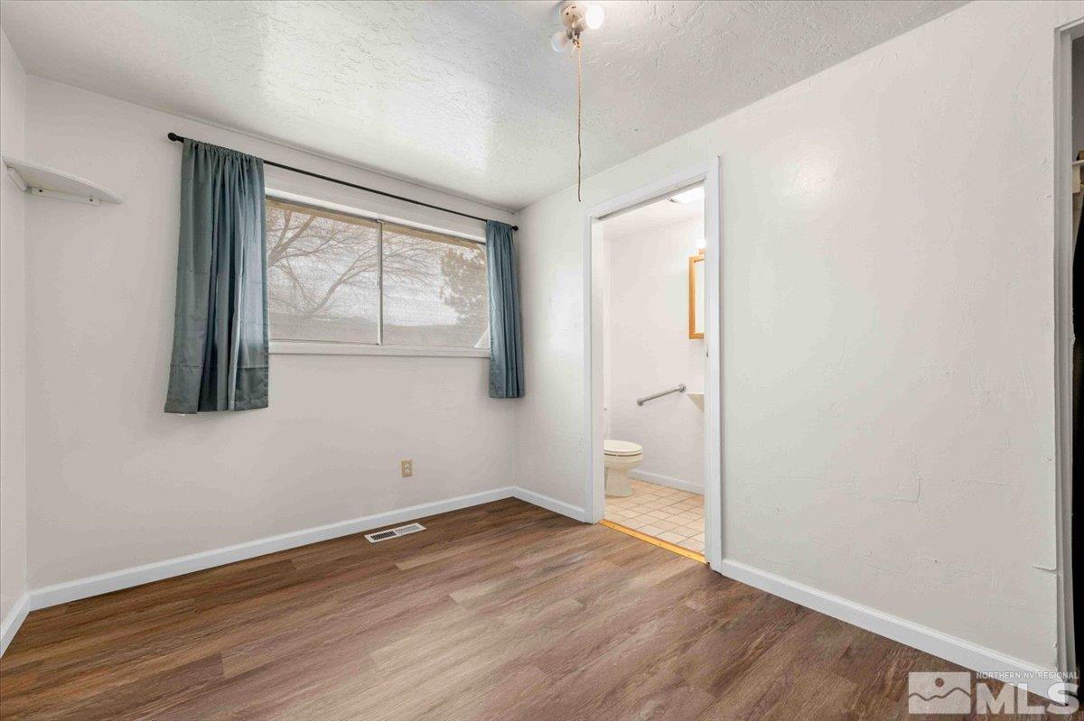 8925 Limnol Street Reno, NV 89506 - Photo 9 of 32 an empty room with wooden floor and windows