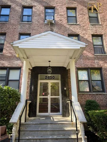front view of a brick house with a yard