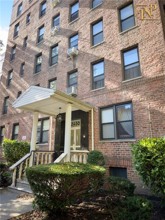 2450 Haring Street, Unit 6D Brooklyn, NY 11235 - Photo 2 of 6 front view of a brick house with a yard