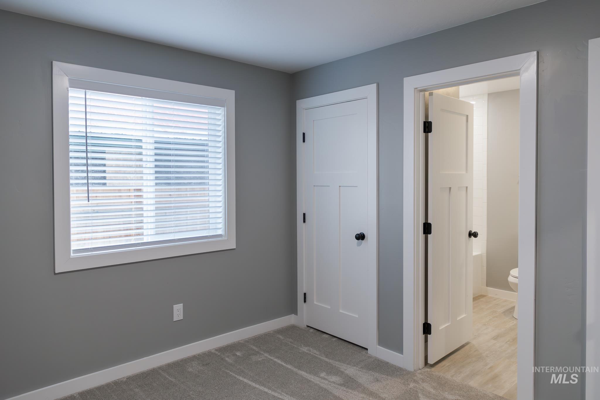 297 Southwest 6th Street, Unit 1 Ontario, OR 97914 - Photo 12 of 50 Unfurnished bedroom with light carpet and ensuite bathroom