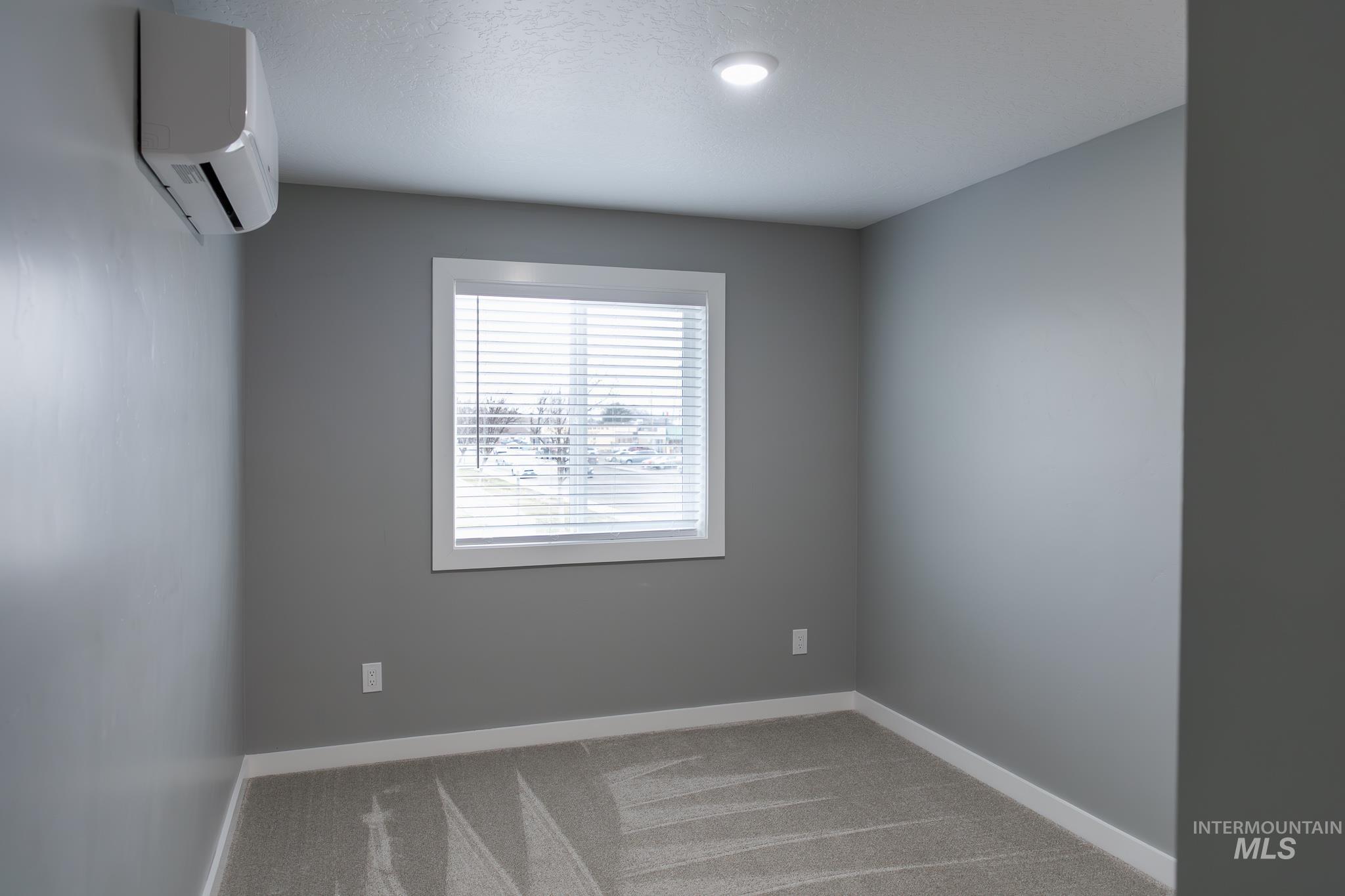 297 Southwest 6th Street, Unit 1 Ontario, OR 97914 - Photo 24 of 50 Unfurnished room featuring a mini split for heating / cooling and light colored carpet