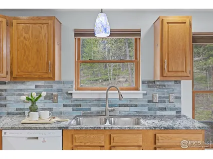 a kitchen with granite countertop a sink stainless steel appliances and cabinets
