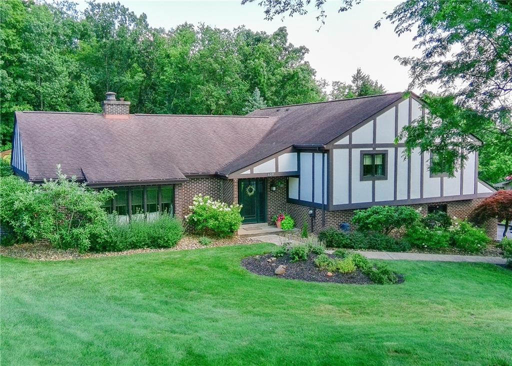 a view of a house with a big yard and a garden