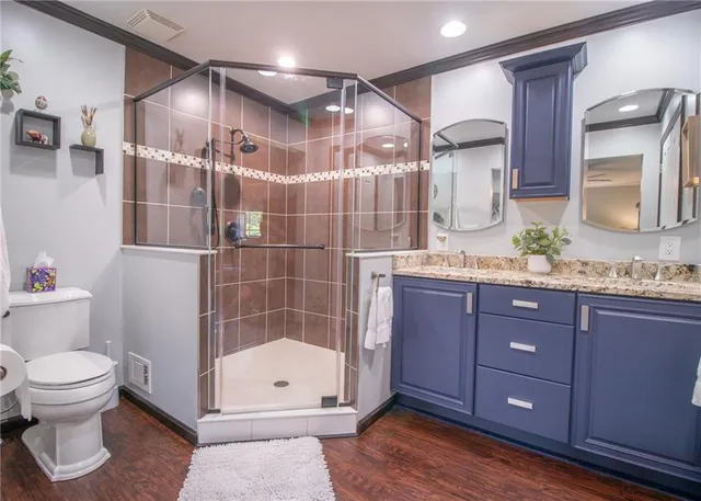 a bathroom with a granite countertop sink toilet and shower